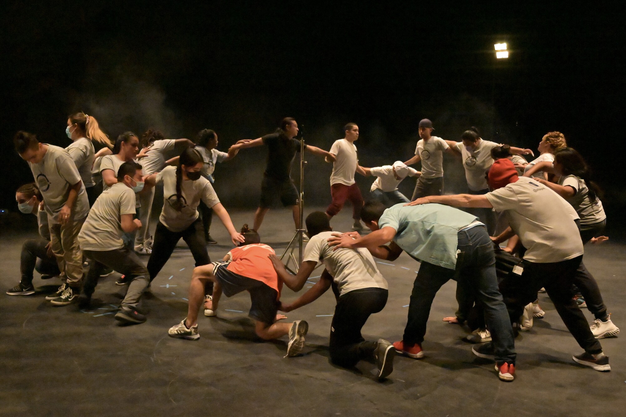The cast of "Stay in Mexico" come together to form a root during a rehearsal of the dance sequence from the new opera.
