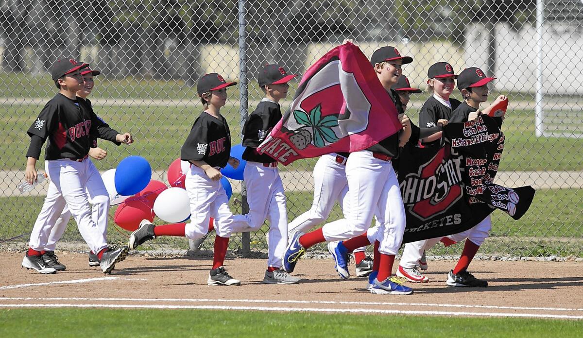 Members of the Minor A division Buckeyes parade their banner during Costa Mesa National Little League opening ceremonies.