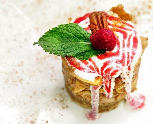 Apple pie is a cunningly textured assemblage of spiced fruit, date-pecan crust, cashew cream and raspberry sauce.