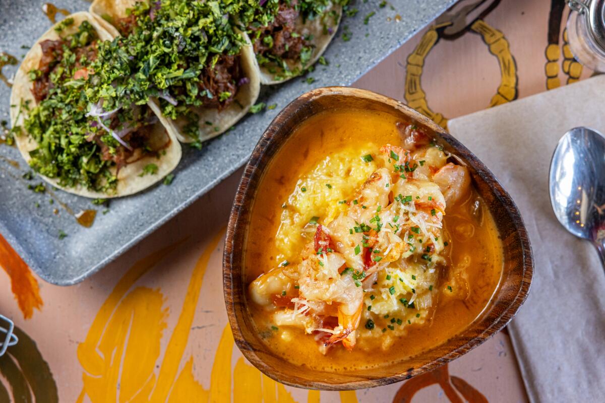 Overhead photo of a trio of tacos and a bowl of shrimp and grits