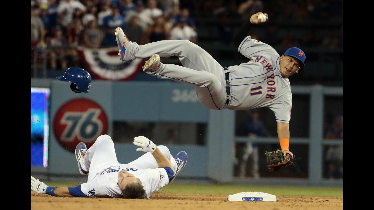 Dodgers second baseman Chase Utley upends Mets shortstop Migue Tejada while breaking up a double play during Game 2 of their playoff series on Oct. 10. Tejada sustained a broken right leg on the play while Utley was ruled safe.