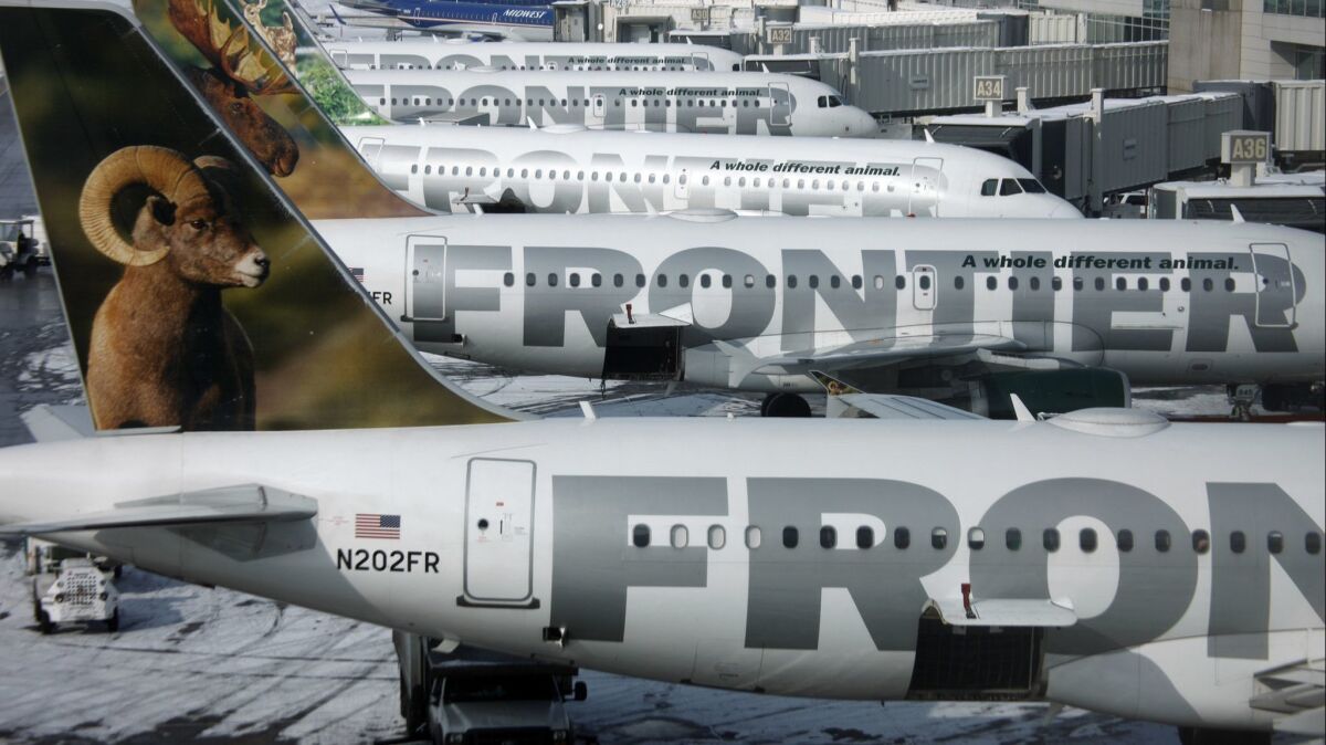 Frontier Airlines jetliners sit stacked up at gates at Denver International Airport in a 2010 file photo. Flight attendants on the carrier can now keep the tips they earn when passengers order food or drinks.