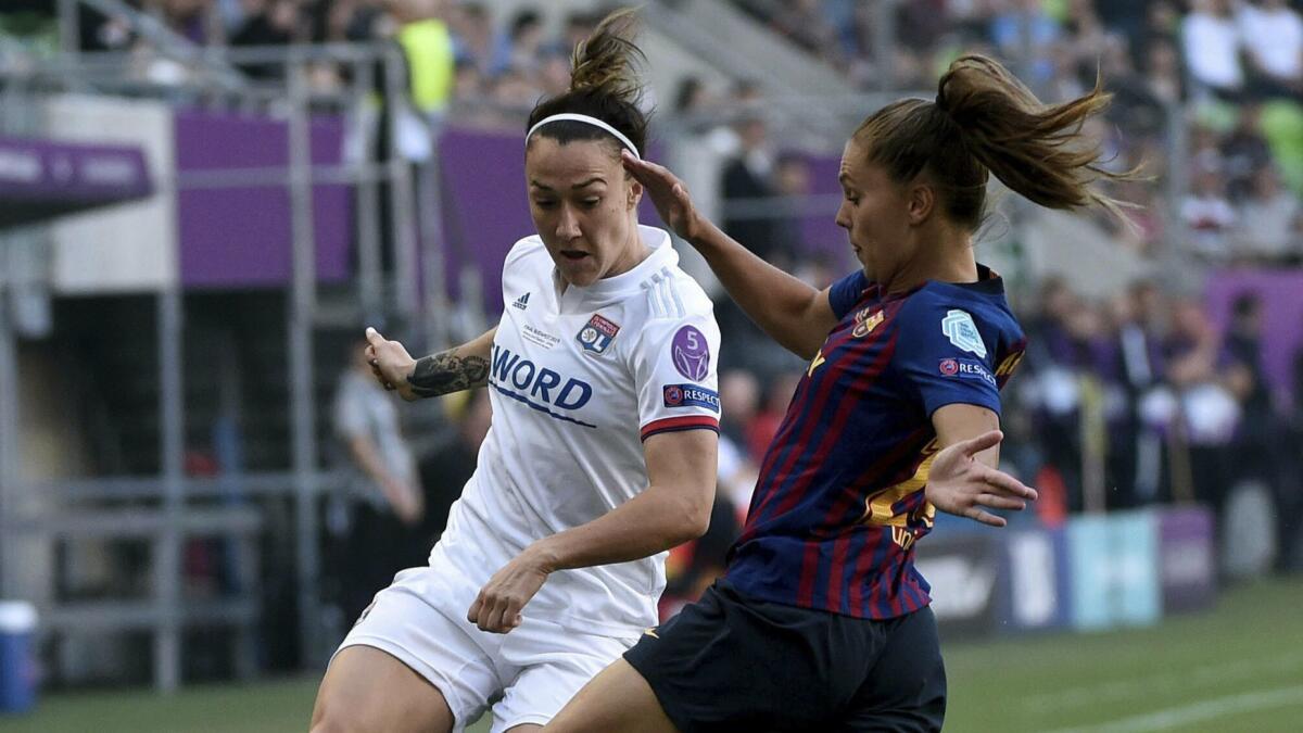 Lucy Bronze, left, battles Lieke Martens for the ball during a UEFA Champions League final between Olympique Lyon and FC Barcelona in Budapest on May 18.