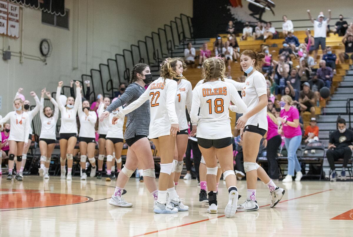Huntington Beach celebrates beating Newport Harbor during a Sunset Conference crossover girls' volleyball match on Tuesday.