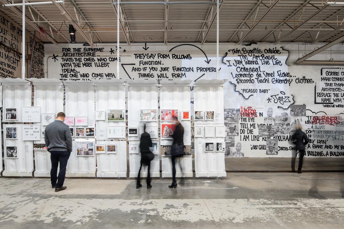 Blurry figures in front of a wall with writing and art