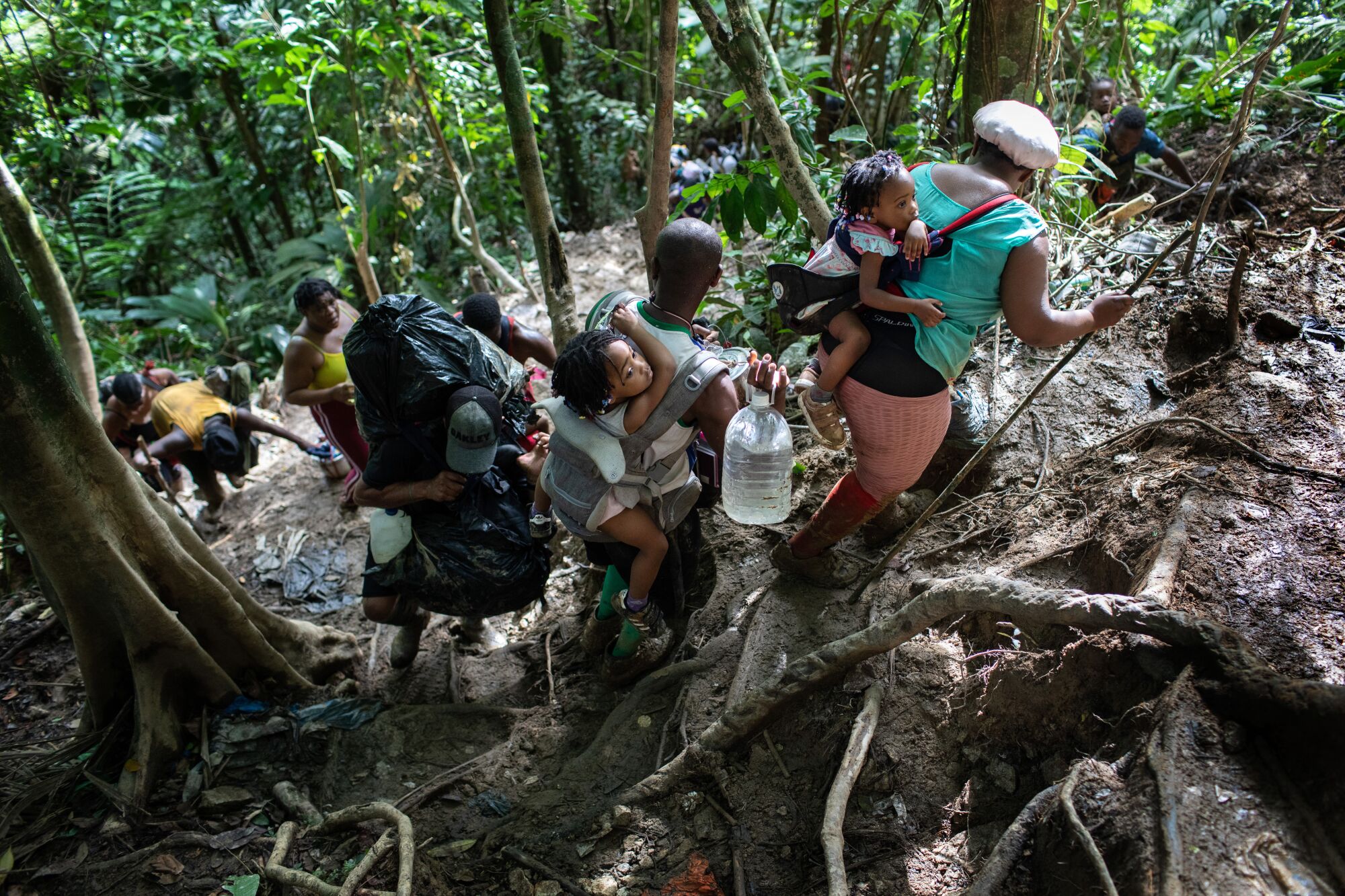 Immigrant families from Haiti climb a steep mountain trail near the border with Panama