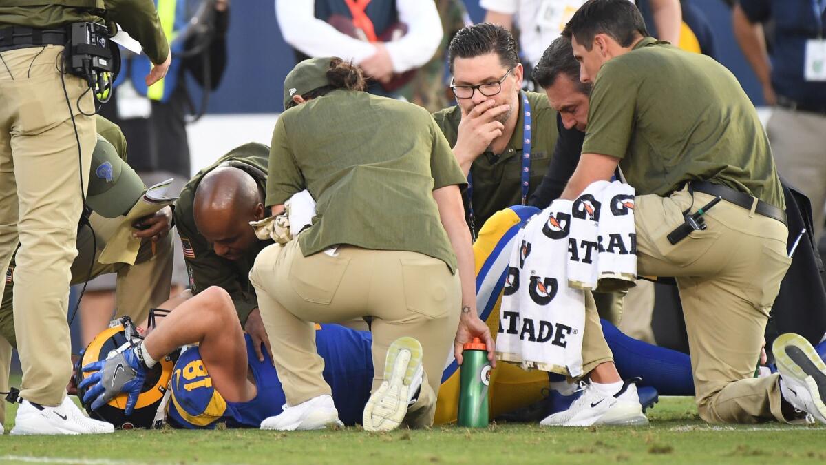 Rams receiver Cooper Kupp holds his head after injuring his knee against the Seattle Seahawks in the fourth quarter at the Coliseum on Sunday.