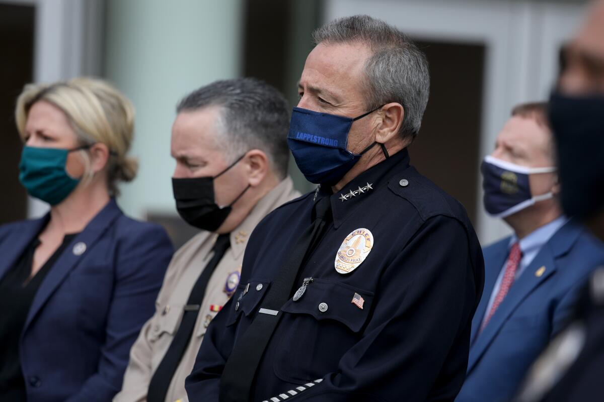 LAPD Chief Michel Moore in a mask while standing with other people in masks
