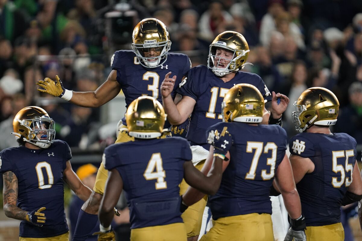Notre Dame wide receiver Avery Davis (3) celebrates his four-yard touchdown reception with quarterback Jack Coan (17) against Southern California in the first half of an NCAA college football game in South Bend, Ind., Saturday, Oct. 23, 2021. (AP Photo/Paul Sancya)