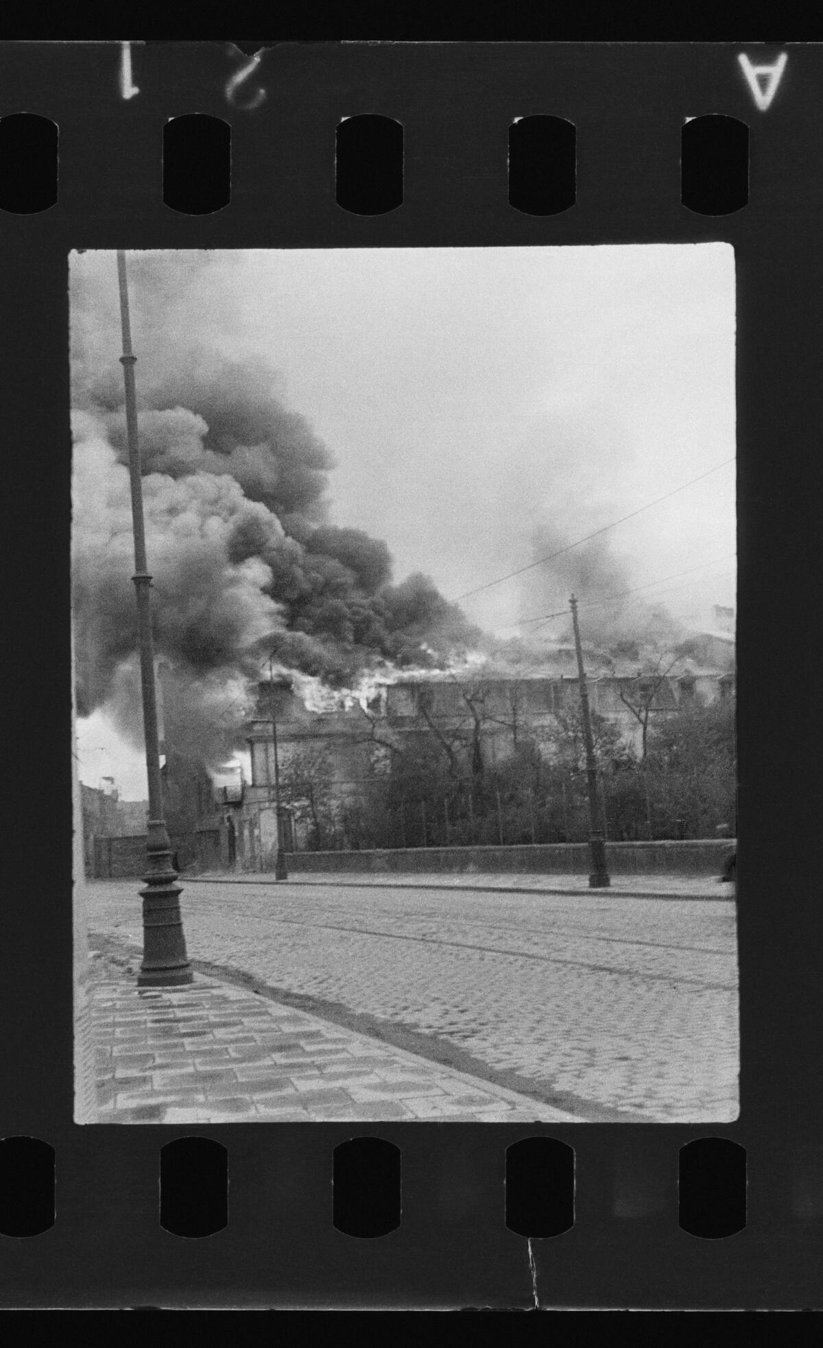Smoke billows from buildings on a Warsaw street in 1943