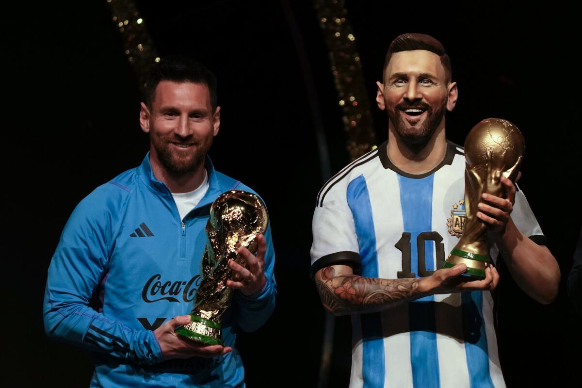 La estrella de Argentina Lionel Messi sostiene una réplica de la Copa del Mundo 