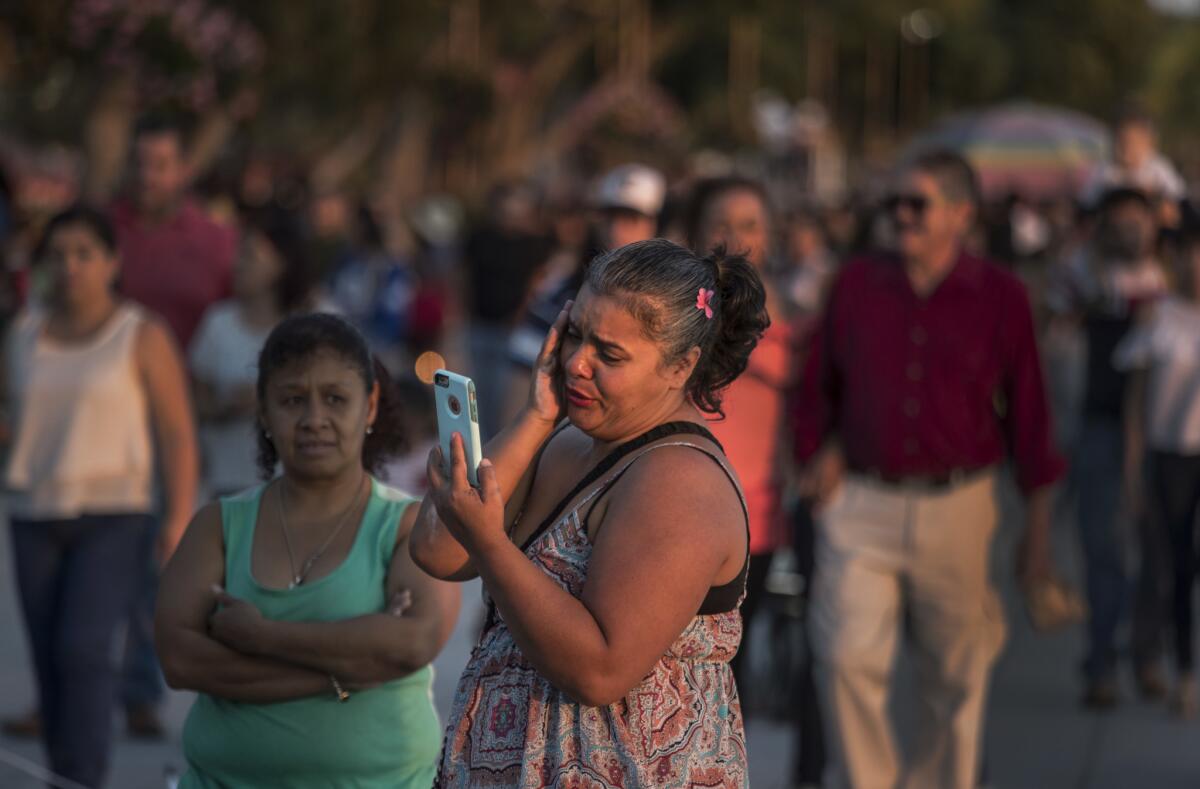 While spending an afternoon with her family on an outing at Lake Chapala, Maria Barrancas weeps while FaceTiming with her son on the crowded boardwalk in November.