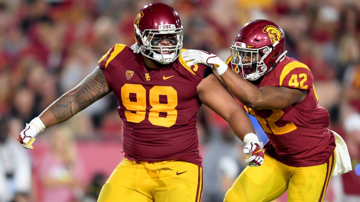 USC defensive tackle Josh Fatu (98) celebrates his sack of Stanford quarterback Keller Chryst with teammate Uchenna Nwosu during the third quarter of their game on Sept. 9.