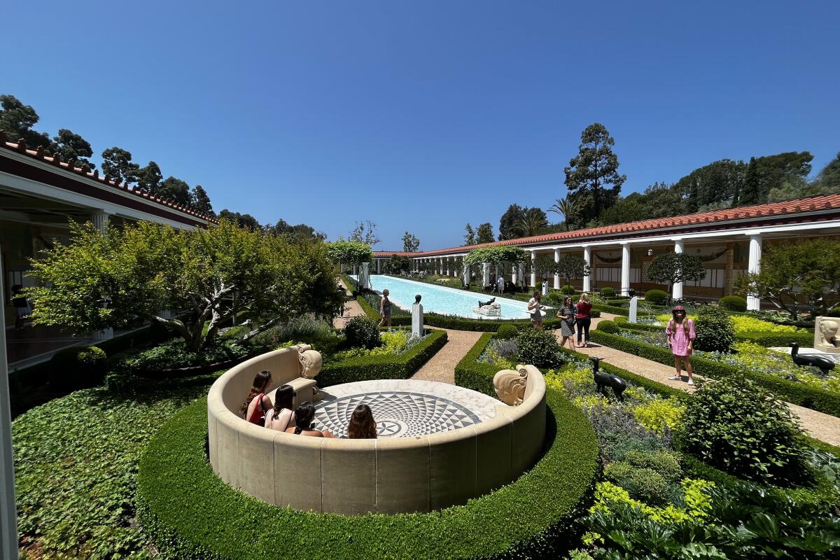 Visitors soak up the sun at the Getty Villa reflecting pool.