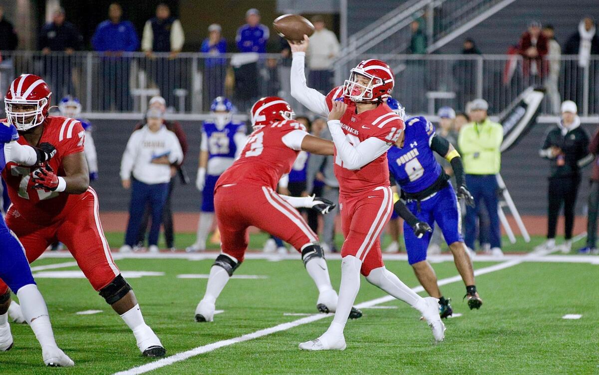 Mater Dei quarterback Elijah Brown throws a pass while surrounded by teammates and opponents.