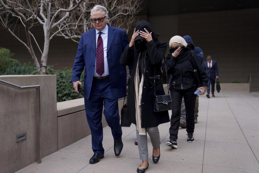 David Chesnoff, left, defense attorney for Alexander Smirnov, walks out of federal court with a group of unidentified people, Monday, Feb. 26, 2024, in Los Angeles. A former FBI informant charged with fabricating a multimillion-dollar bribery scheme involving President Joe Biden’s family must remain behind bars while he awaits trial, a judge ruled Monday, reversing an earlier order releasing the man. (AP Photo/Eric Thayer)