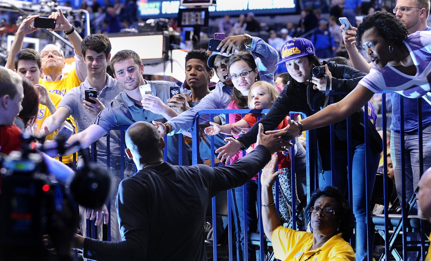 Kobe Bryant high-fives fans as he returns to the court during halftime against the Thunder in Oklahoma City on April 11.