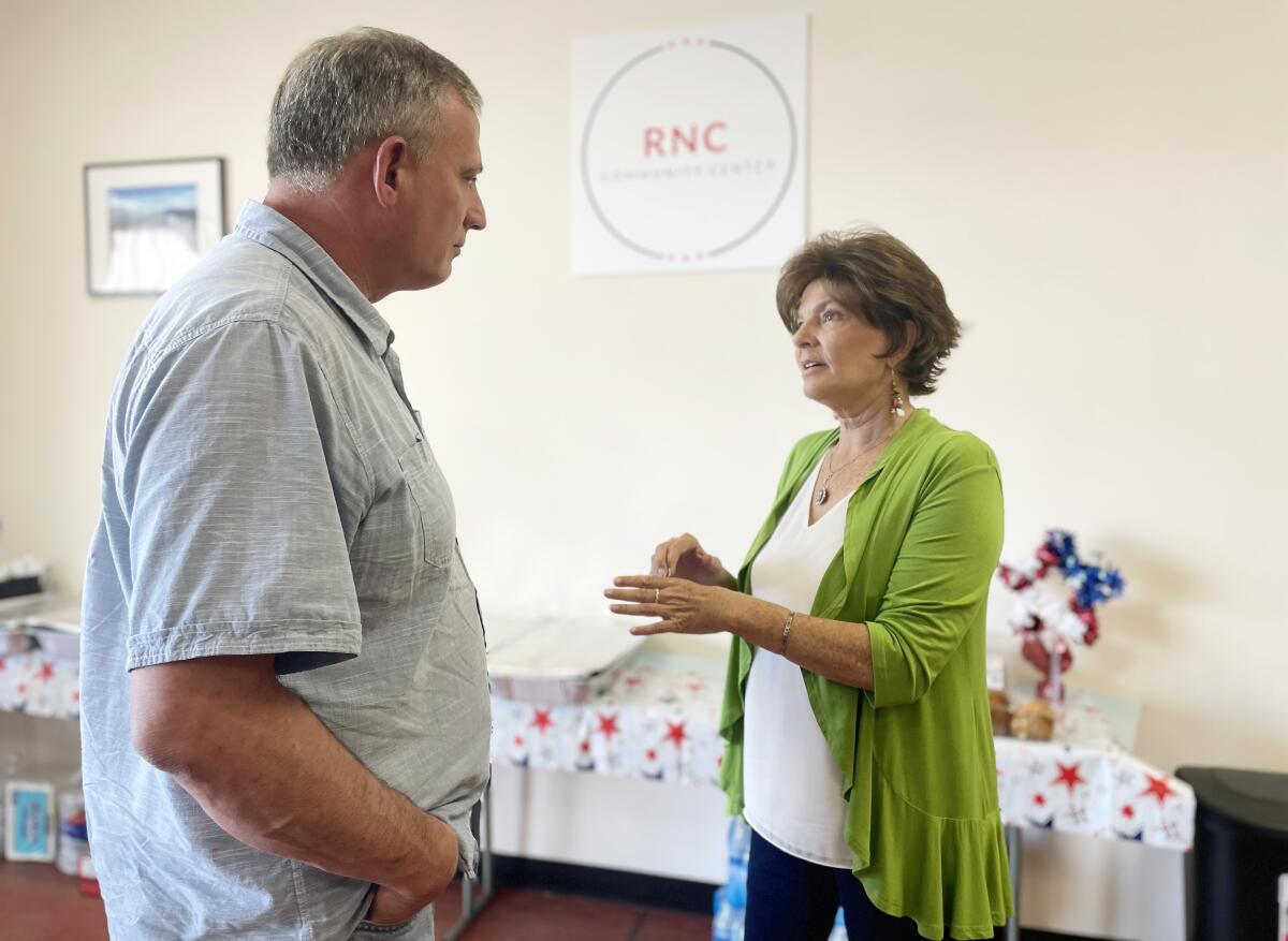 Rep. Yvette Herrell speaks to a man at the RNC Hispanic Community Center in Albuquerque.