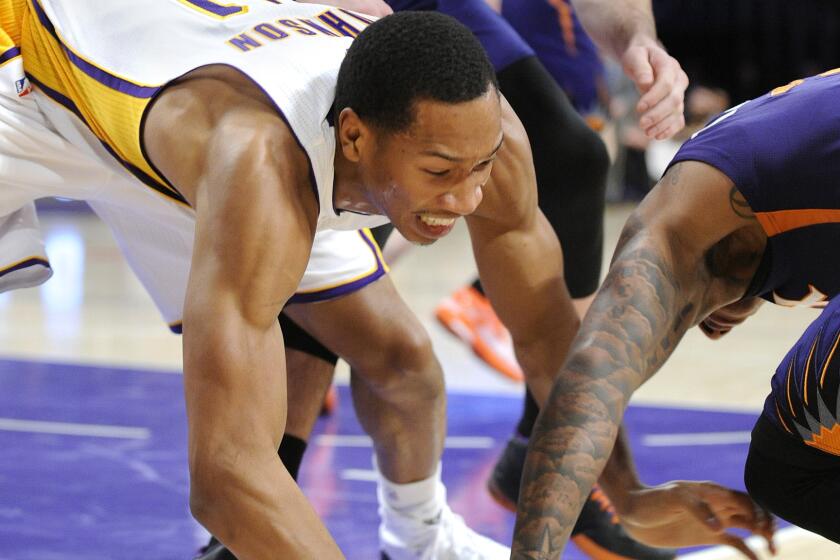 Lakers forward Wesley Johnson, left, and Suns guard Isaiah Thomas chase after a loose ball during a game at Staples Center on Dec. 28, 2014.