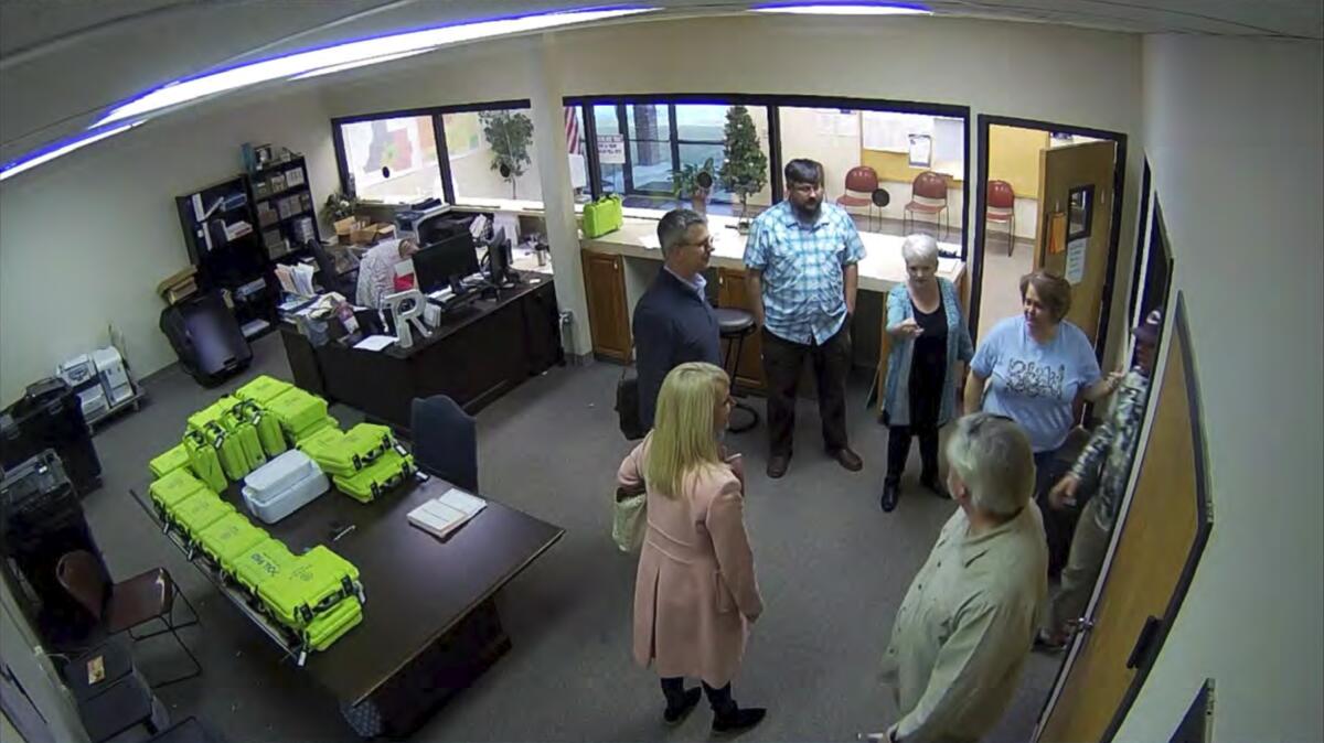 Image from surveillance video shows several people standing in an office