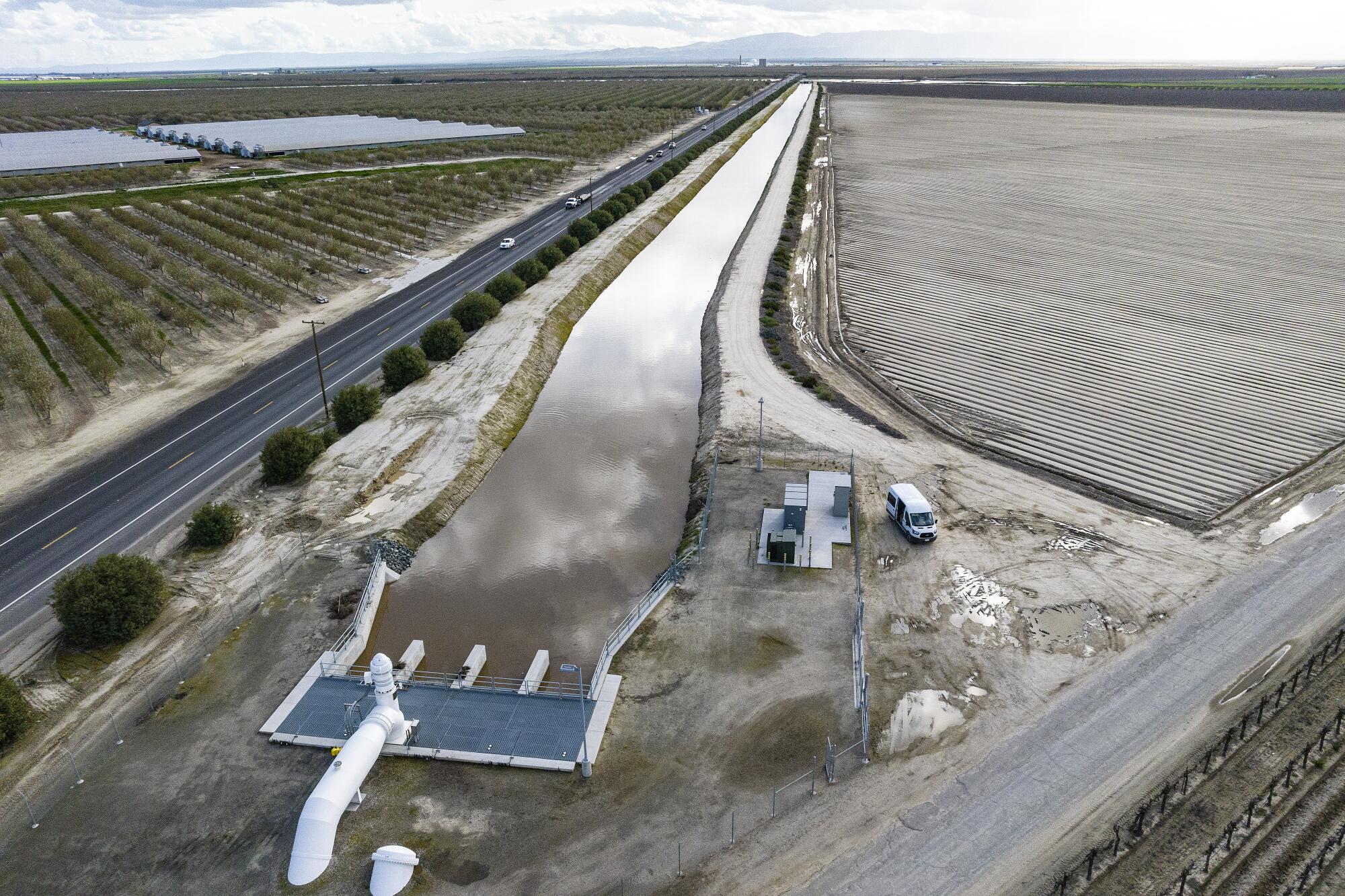 A waterway next to a road and fields.