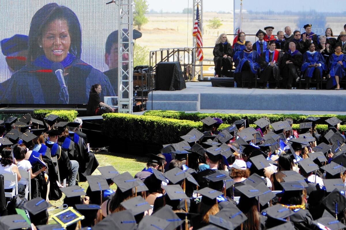 First Lady Michelle Obama, projected on an LED screen, gives the commencement address for the first full graduating class at UC Merced in May 2009. Students and staff had bombarded her with postcards, valentines and a video in which the narrator says: "Dear Michelle, we believe in you and we would be honored if you could be our keynote speaker."