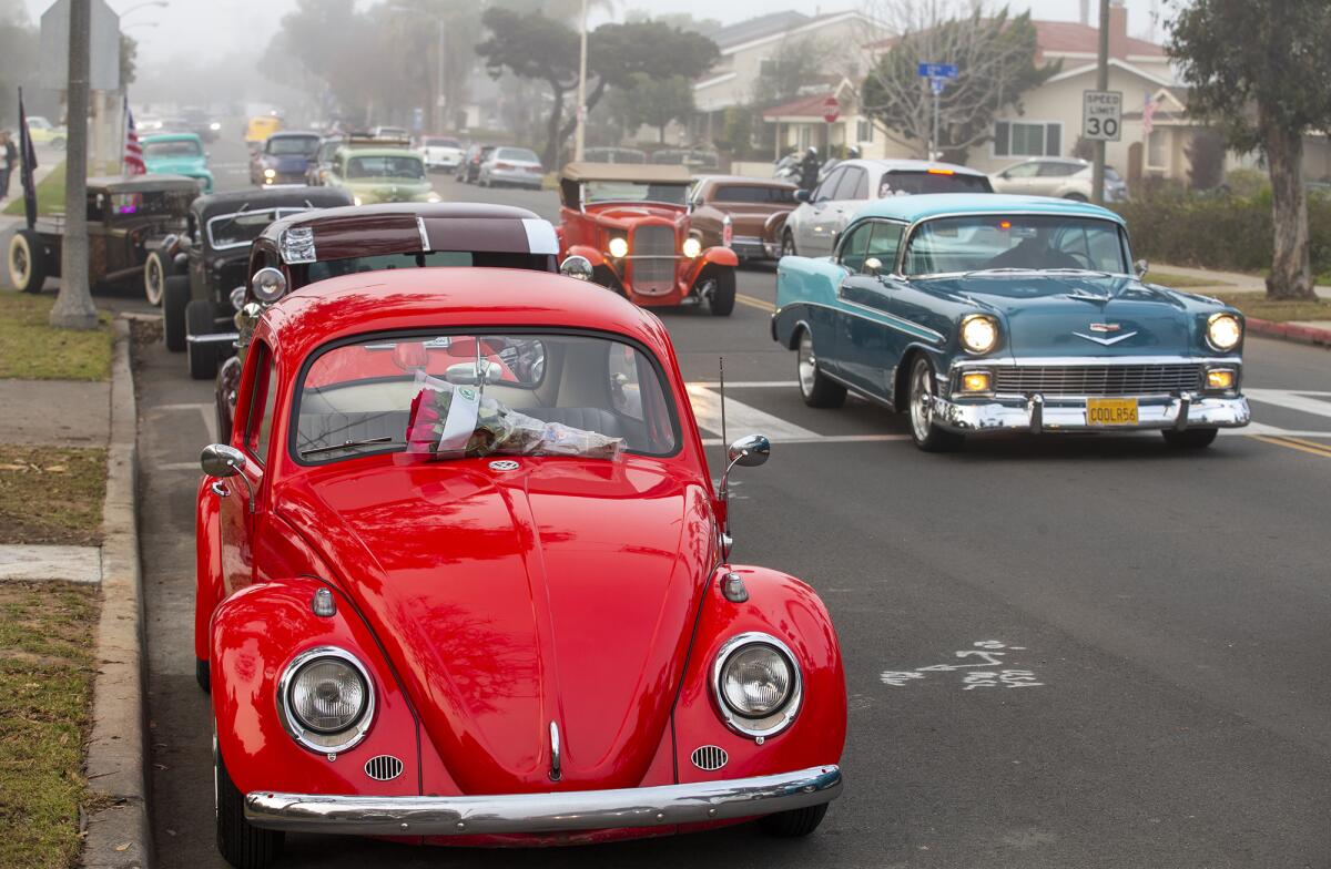 Classic cars line Lake Park during a memorial ride for Daniel Patten and Tommy Simpson.