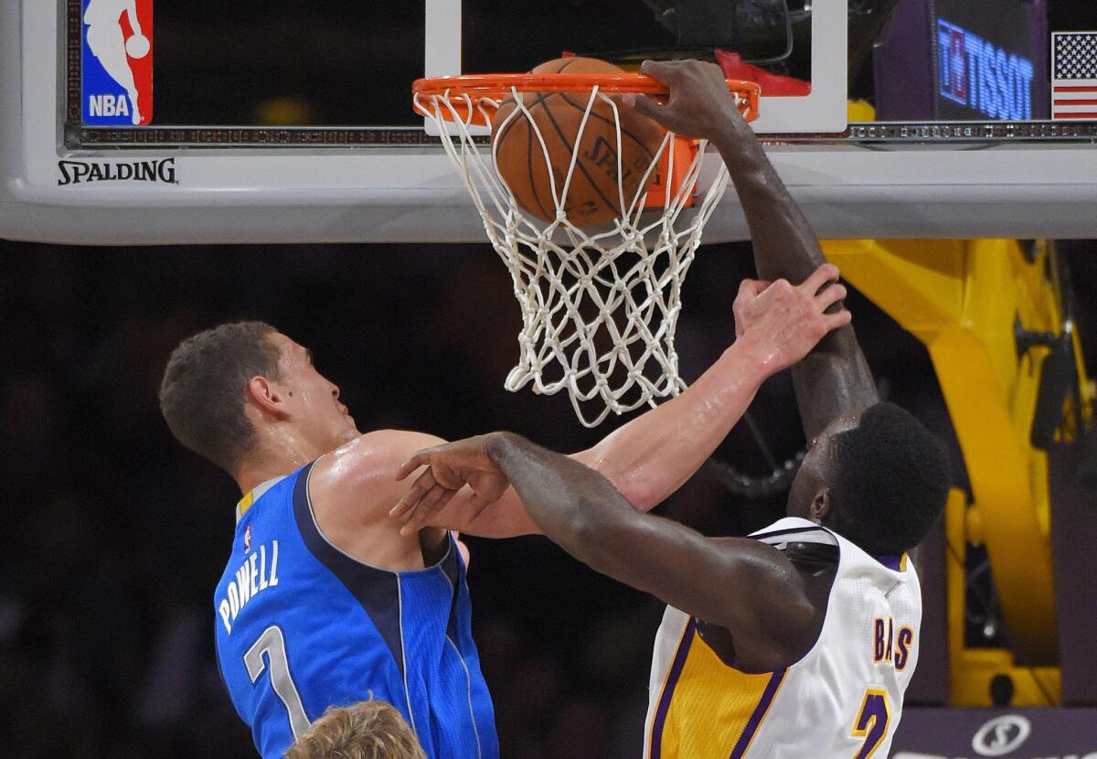 Los Angeles Lakers forward Brandon Bass, right, dunks in front of Dallas Mavericks forward Dwight Powell during the first half on Sunday.