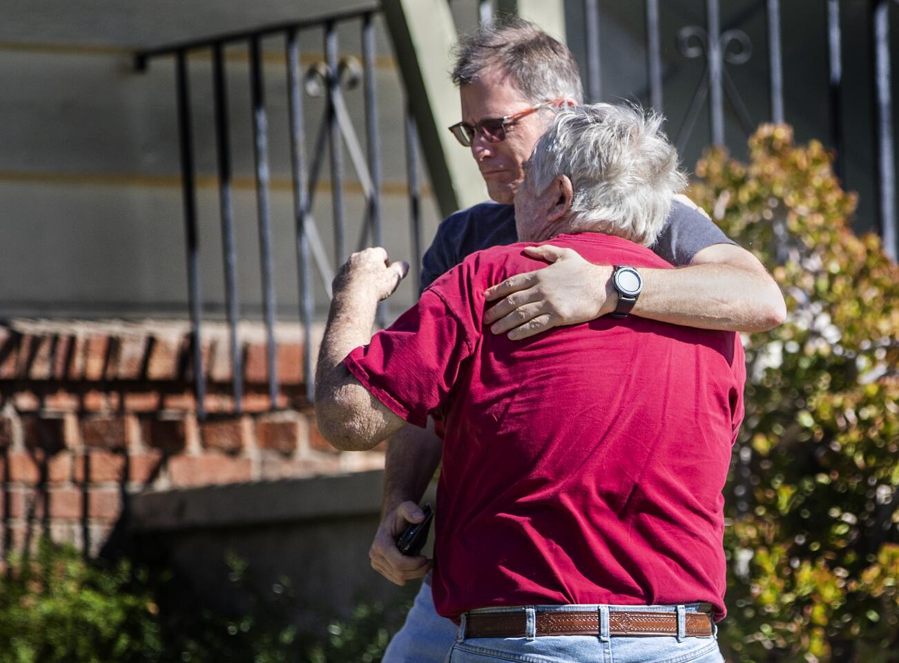 Rob Haberkorn, 71, gets a hug from his son Robert W. Haberkron after returning to his home and finding it unscathed after the Hillside fire burned through the area in San Bernardino.