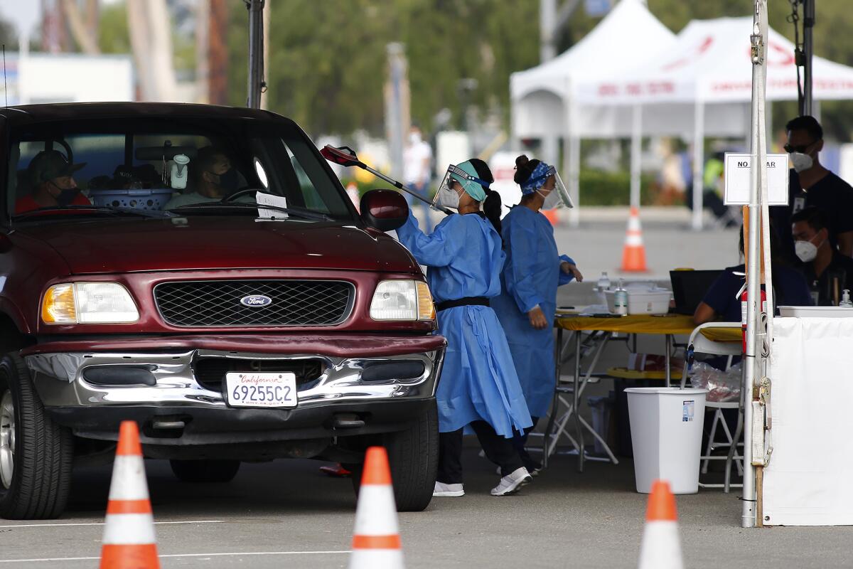 A worker from 360 Clinic passes a COVID-19 self-administering test at a drive-through testing site on Wednesday.