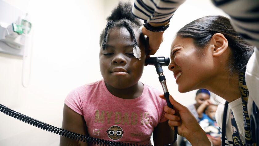 Cianna Allen, 8, is examined by Dr. Patricia Campbell at St. John's Wellness & Family Center in Los Angeles. Cianna's mother says they have lived in their car and stayed at the Union Rescue Mission.