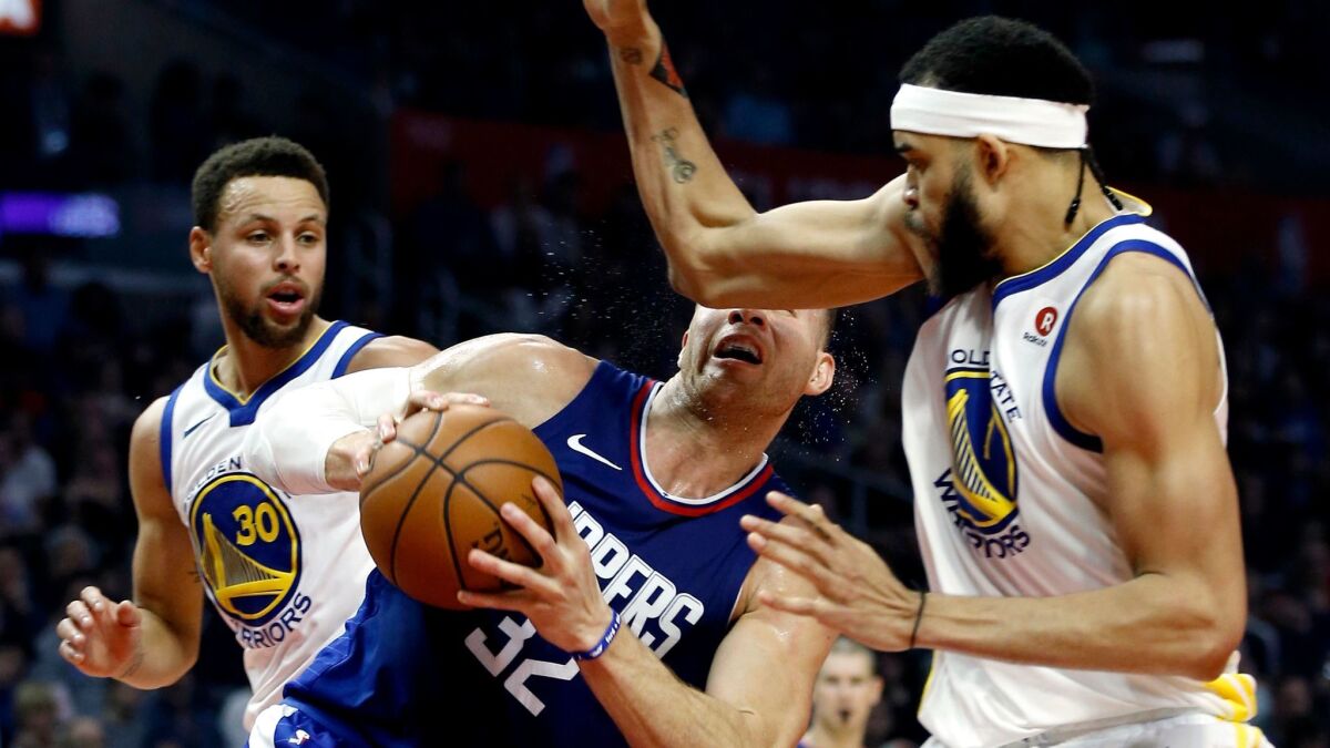 Clippers forward Blake Griffin is struck in the face by Warriors center JaVale McGee during a drive to the basket in the first quarter Saturday. Griffin left with a concussion and will be sidelined for at least one game and possibly more.