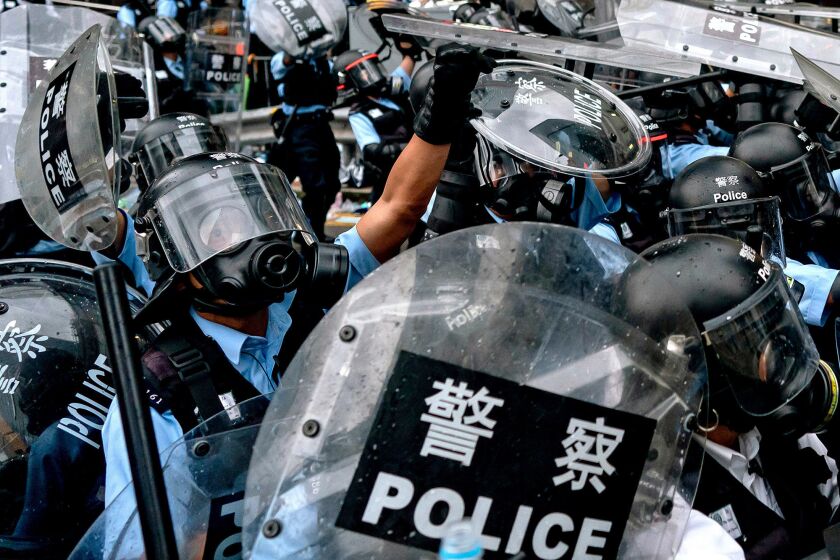 Riot police in Hong Kong surge toward protesters on June 12.