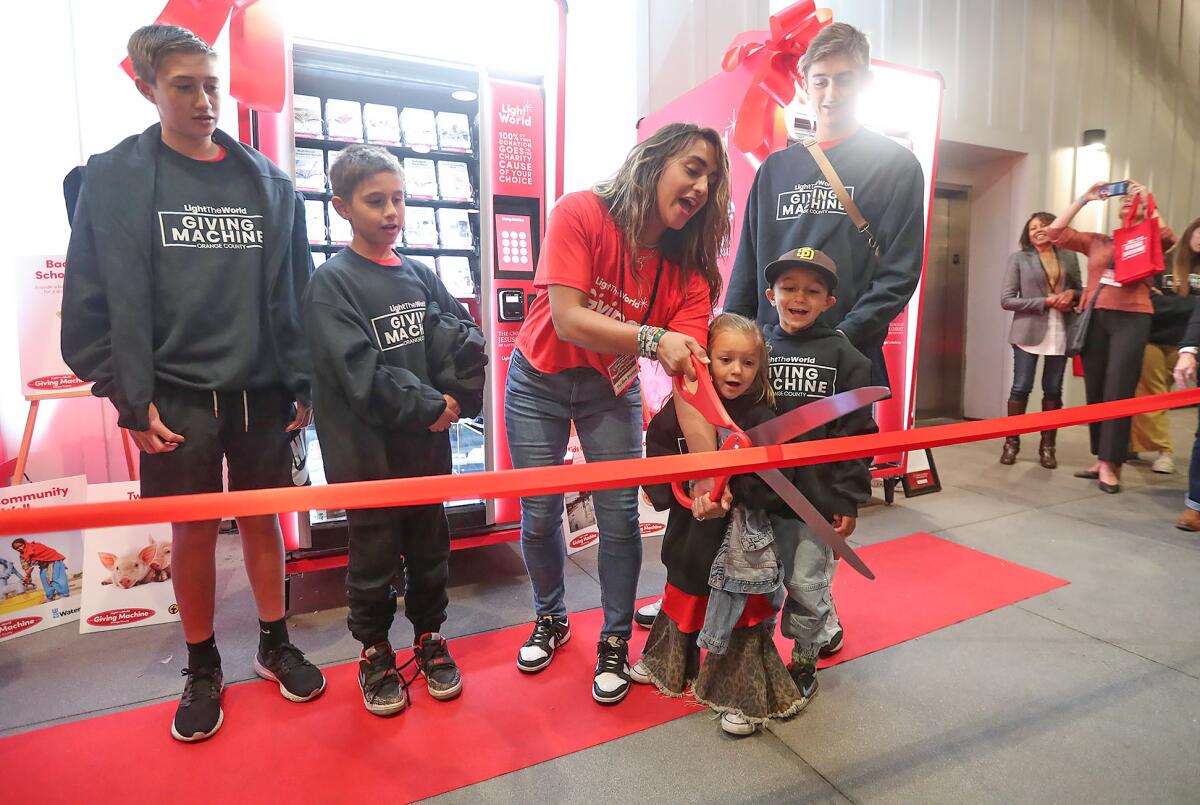 Tia Stokes, mom, with scissors, with the rest of her family, cuts the ribbon.