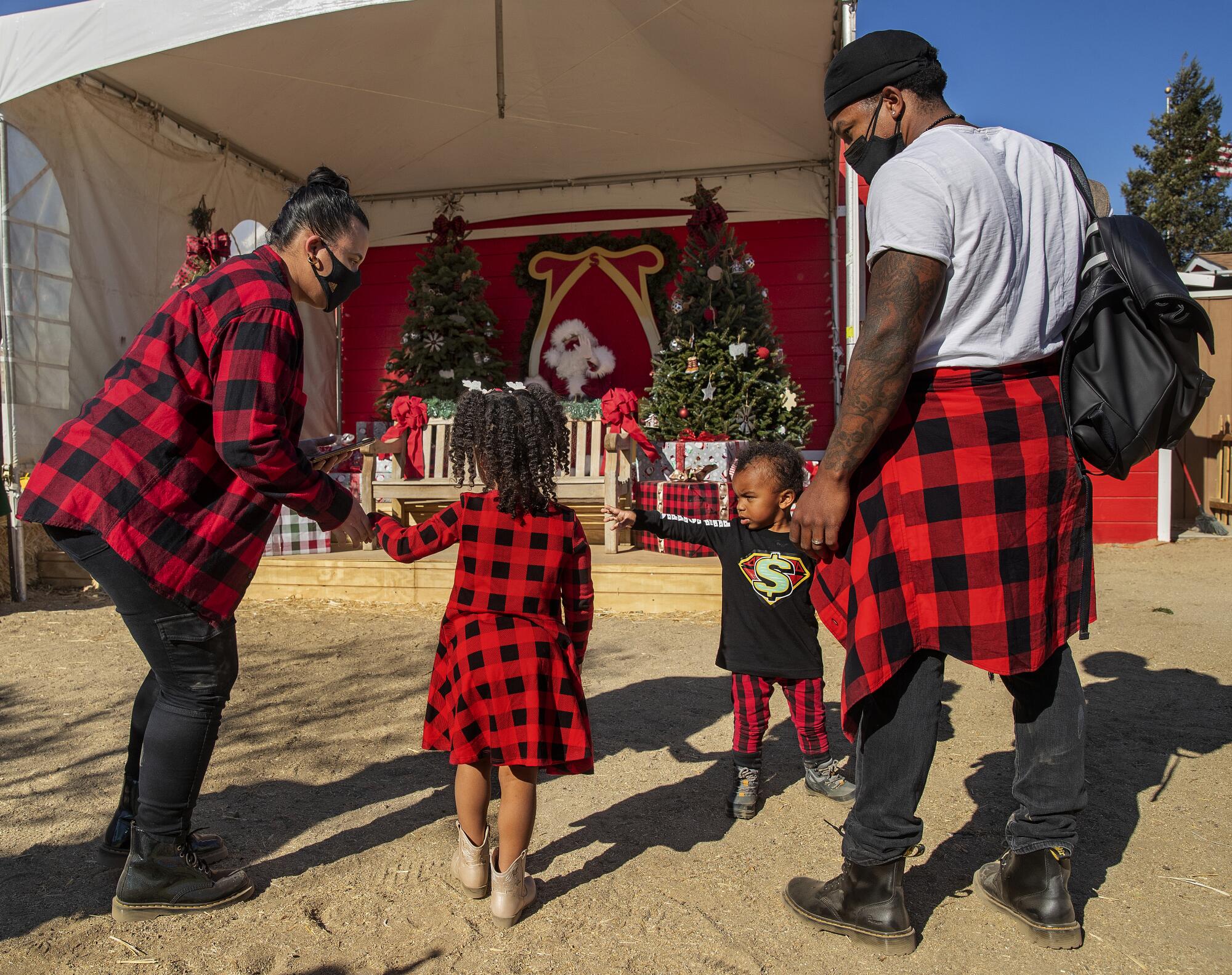 A family of four are dressed in matching red checkered clothing