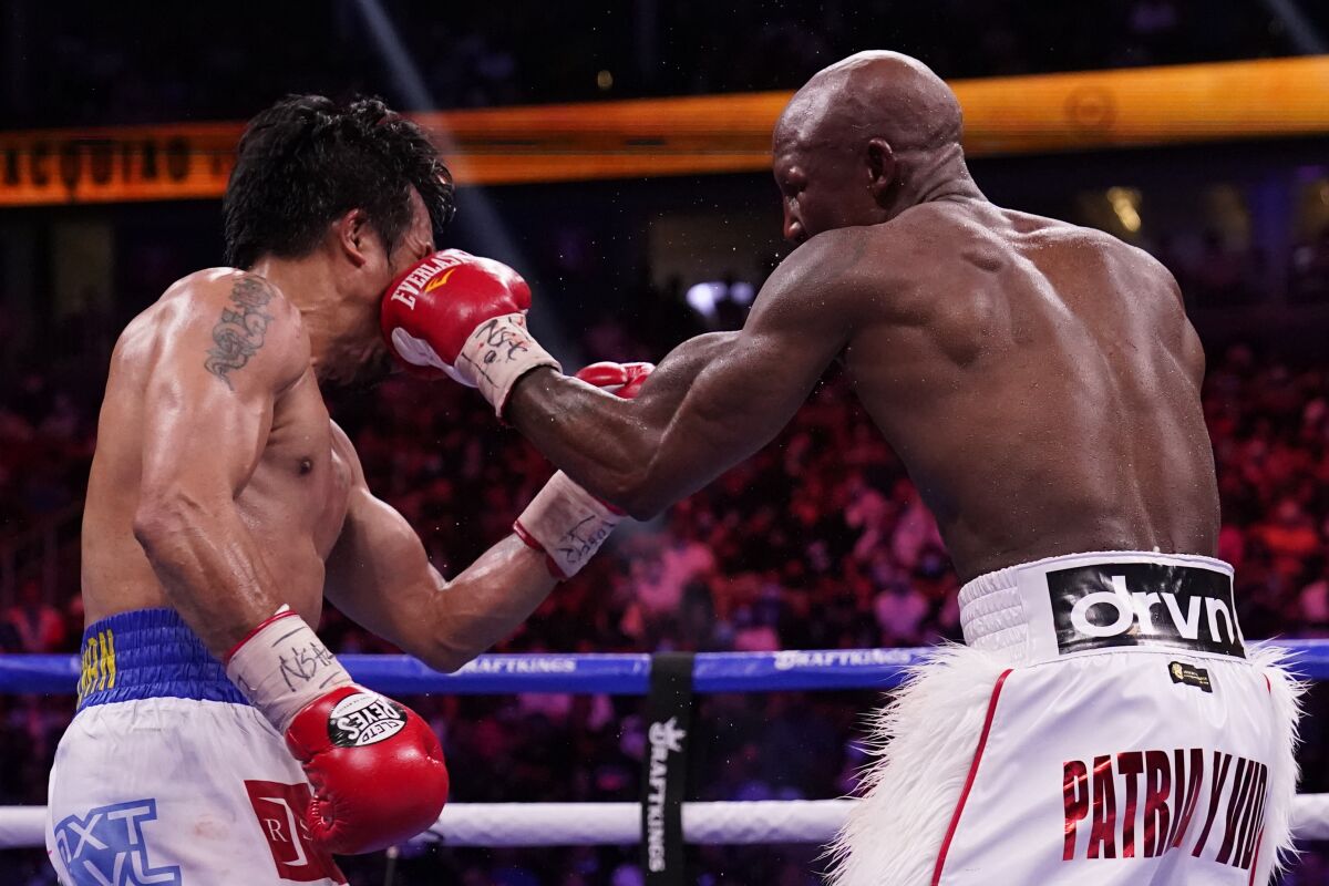 Yordenis Ugas, right, of Cuba, hits Manny Pacquiao, of the Philippines