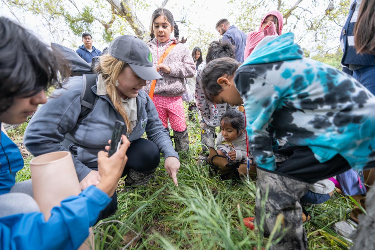 Kids listen as a staff member from the Irvine Ranch Conservancy instructs them on how to collect data.