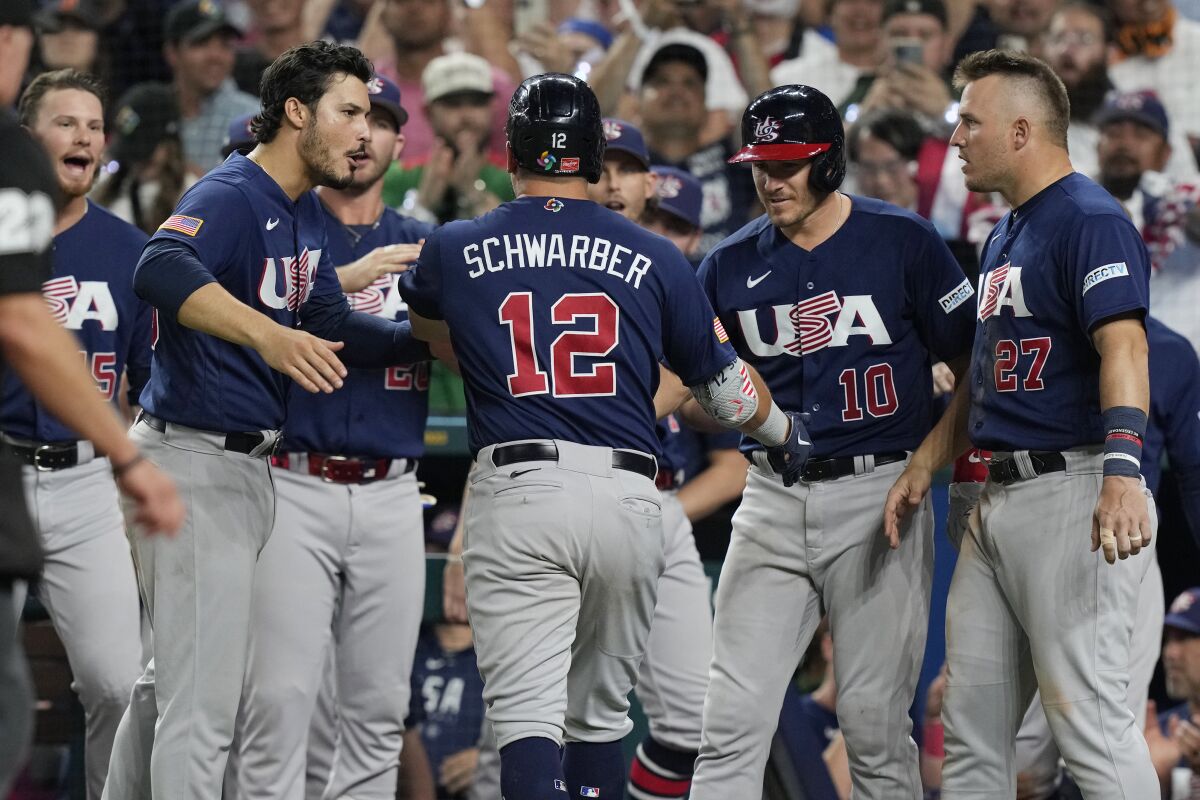 The U.S. team congratulates Kyle Schwarber after hitting a home run.