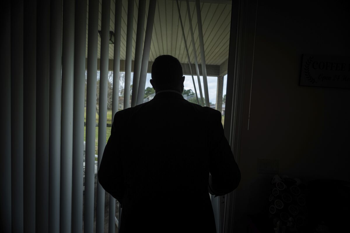 Joseph Moore looks out of a window at his home in Jacksonville, Fla.