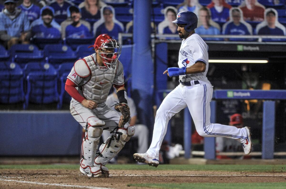 Angels catcher Kurt Suzuki waits for the throw as the Blue Jays' Marcus Semien scores in the fourth inning.