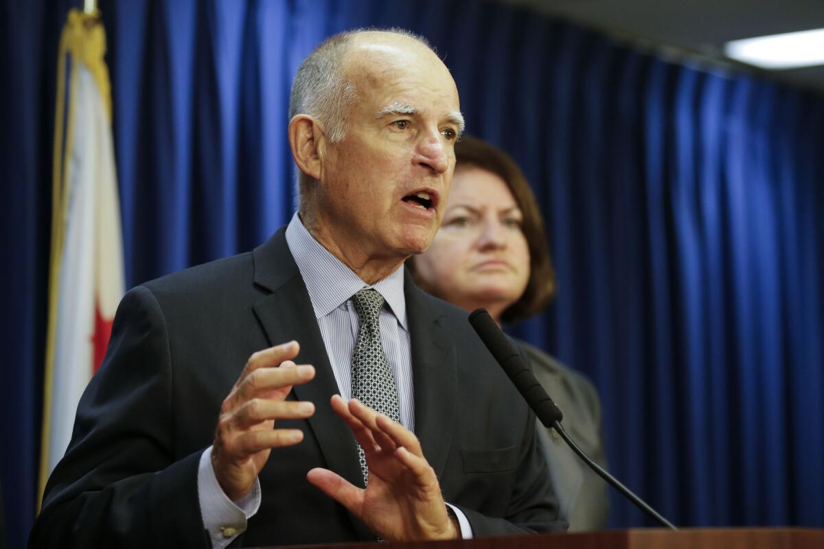 California Gov. Jerry Brown, left, speaks at a June press conference.