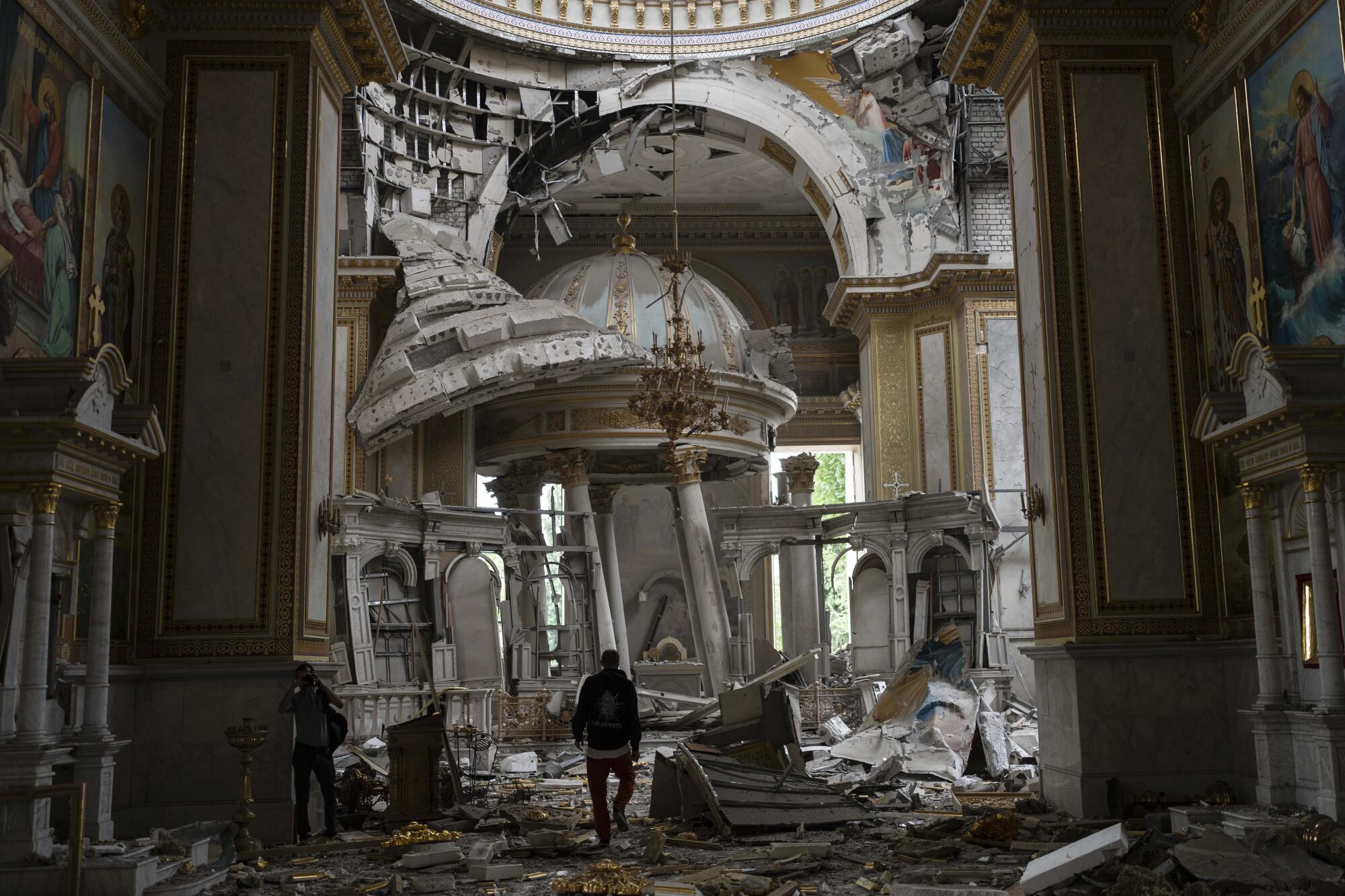 A person walks through a badly damaged cathedral