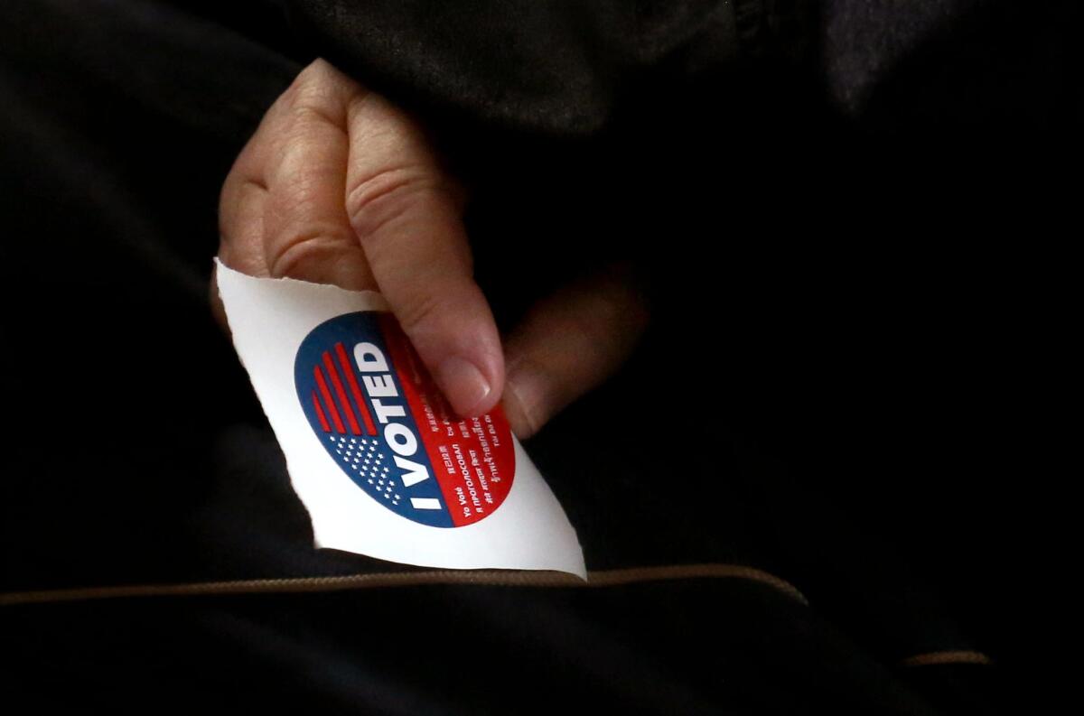 A voter holds his "I Voted" sticker in West Hollywood on Nov. 8. 