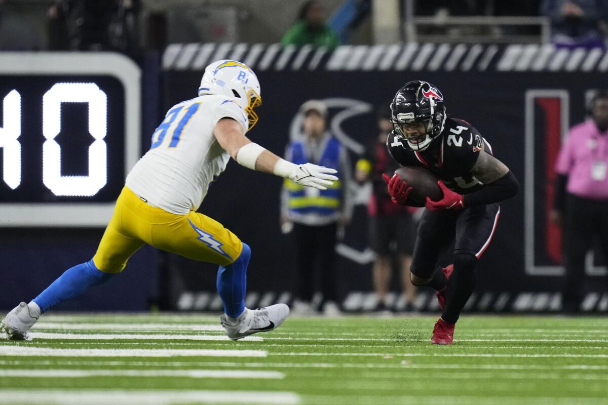The Texans' Derek Stingley Jr. (24) intercepts a pass that bounced of the hands of the Chargers' Will Dissly (81).