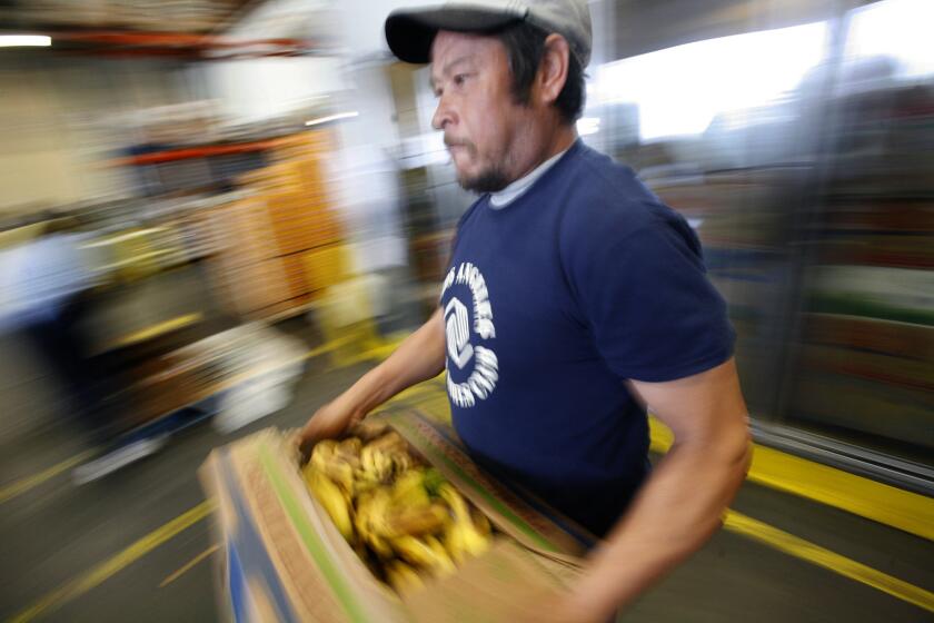 David Navarro of the Los Angeles Boys and Girls Club hand picks food items at The Los Angeles Food Bank on 41st Street.