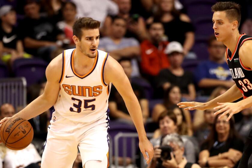 PHOENIX, AZ - OCTOBER 05: Dragan Bender #35 of the Phoenix Suns handles the ball guarded by Zach Collins #33 of the Portland Trail Blazers during the second half of the NBA preseason game at Talking Stick Resort Arena on October 5, 2018 in Phoenix, Arizona. NOTE TO USER: User expressly acknowledges and agrees that, by downloading and or using this photograph, User is consenting to the terms and conditions of the Getty Images License Agreement. (Photo by Christian Petersen/Getty Images) ** OUTS - ELSENT, FPG, CM - OUTS * NM, PH, VA if sourced by CT, LA or MoD **