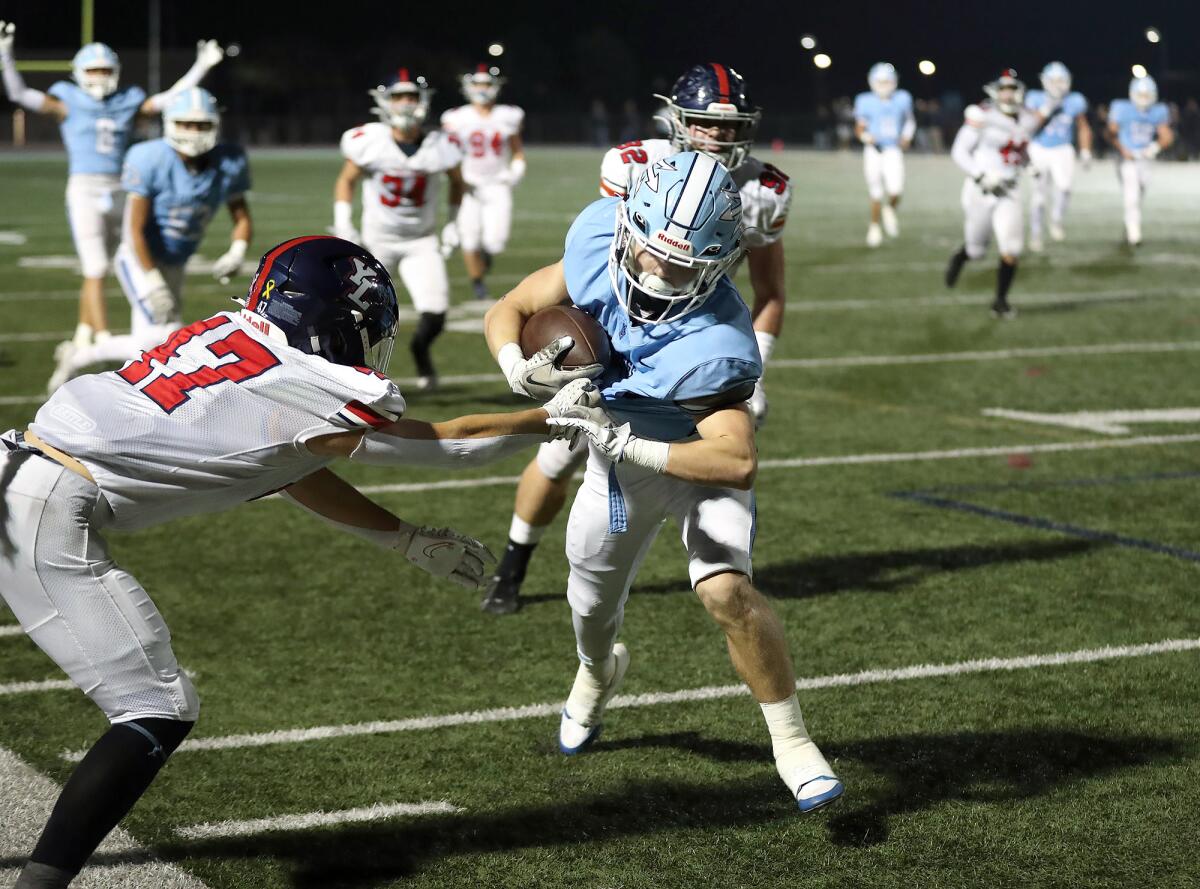 Corona del Mar's Wyatt Lucas eludes a tackle by Yorba Linda's Troy Roberts and heads into the end zone on Friday night.