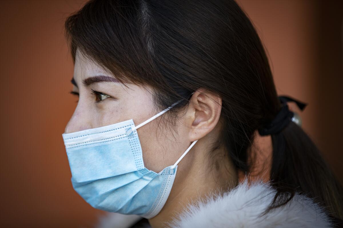 Emily Wuxue of Monterey Park wears a mask amid coronavirus fears while shopping at Ranch Market in San Gabriel.