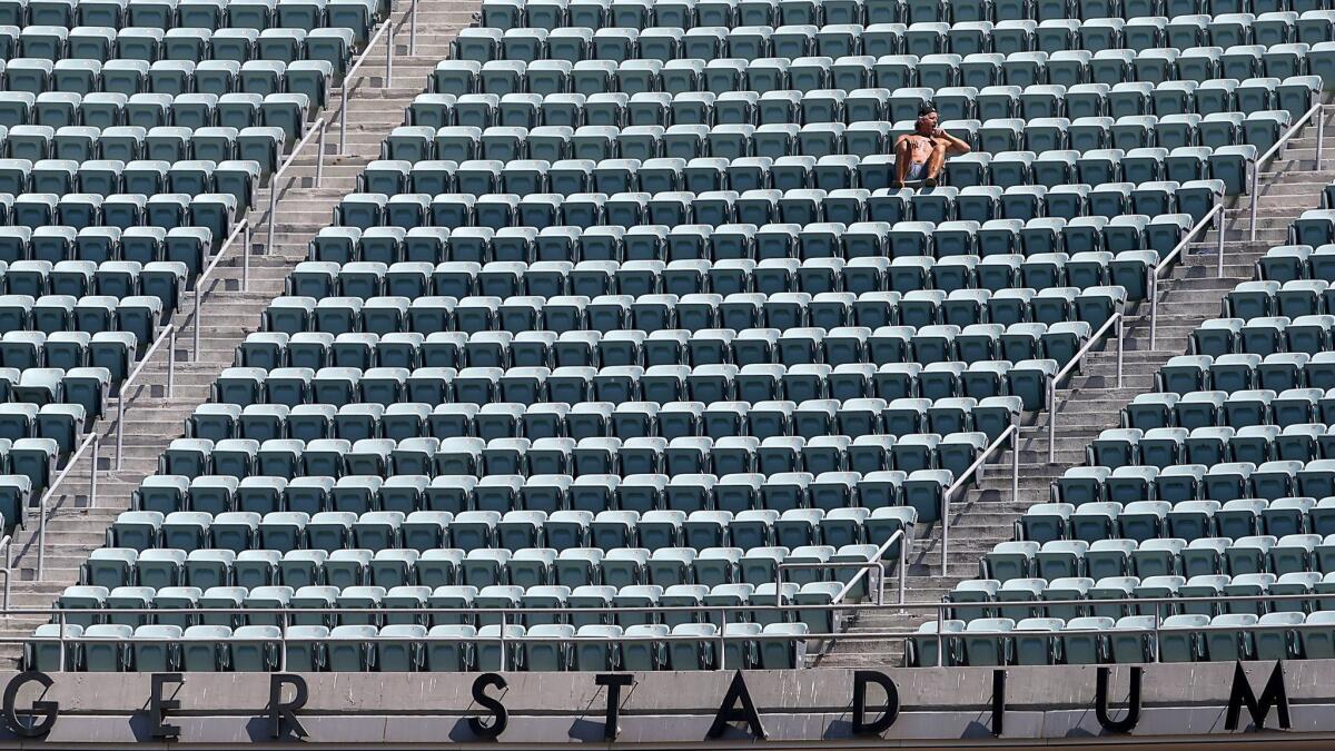 A fan sits amid empty seats in the upper deck at Dodger Stadium.