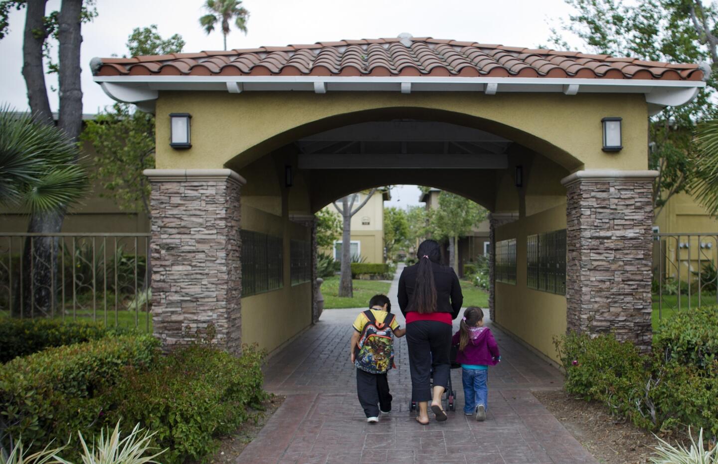A woman and two small children are seen at Villa del Sol apartments in Santa Ana, the same complex where a woman claims she was kidnapped 10 years ago.